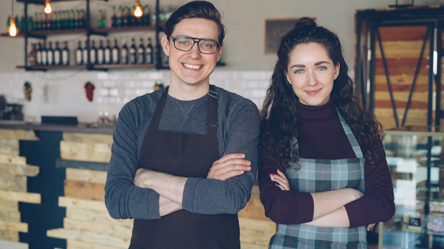 Two small business owners standing together in front of their Charlotte cafe counter